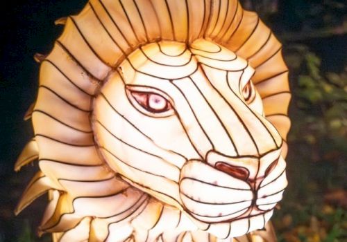 This image features a decorative lantern shaped like a lion's head, illuminated with intricate detailing and lines.